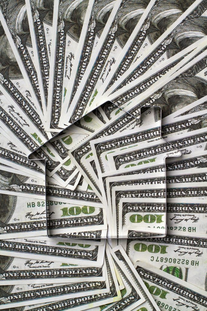 Frame shaped house on a pile of money.